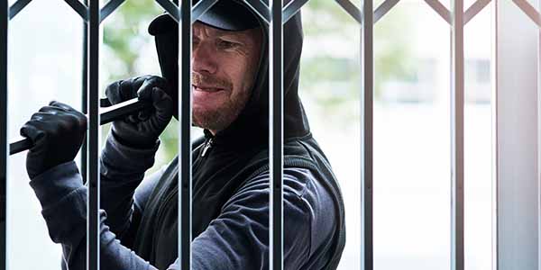 A burglar trying to break a security gate 